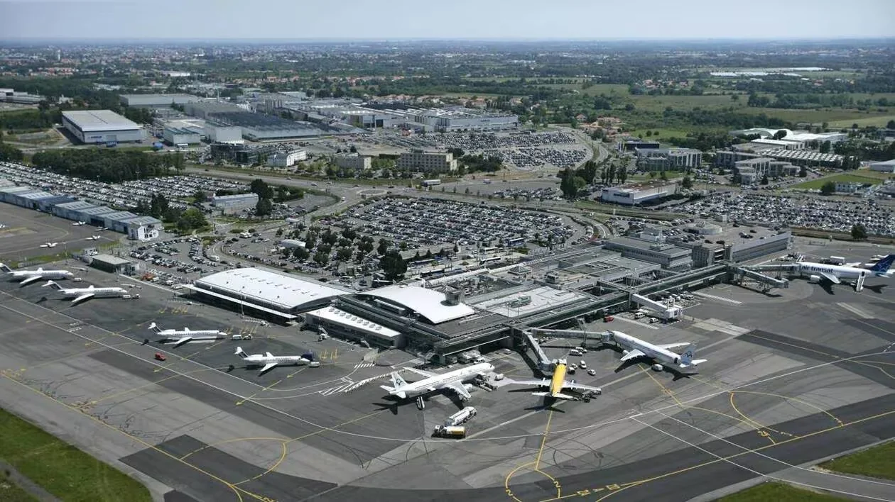 Aerial view of Nantes Atlantique Airport: terminal, aircraft on the ground, and parking lots